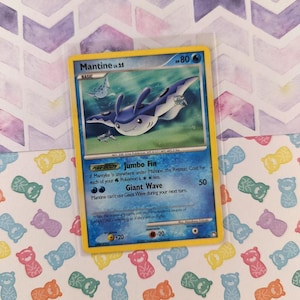 May include: A Pokemon trading card featuring Mantine lv.25 with a blue and white design. The card has a yellow border and includes text about its abilities. The background is a patterned design.