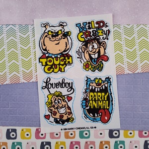 May include: A sheet of stickers featuring four cartoon characters. The characters are a dog with a cigar, a man with a wild hairstyle, a man with a mustache and a heart, and a blue monster with a drink. The text on the stickers reads "Touch Guy", "Wild & Crazy", "Loverboy", and "Party Animal".