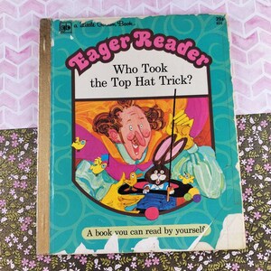May include: Vintage children's book titled "Eager Reader: Who Took the Top Hat Trick?" with a teal cover. The cover features a cartoon illustration of a magician, a rabbit, and other characters. The book is a "Little Golden Book."