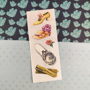 Peut inclure: Une planche d'autocollants avec des illustrations de mode vintage. Les motifs comprennent une chaussure jaune, un chapeau avec un accent floral, un sac à main et des gants. Le fond est bleu foncé avec des motifs de papillons turquoise.