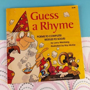 May include: A vintage children's book titled "Guess a Rhyme" with a yellow cover. The cover features a cartoon illustration of a wizard, a ram, and musical instruments. The book includes poems and riddles.