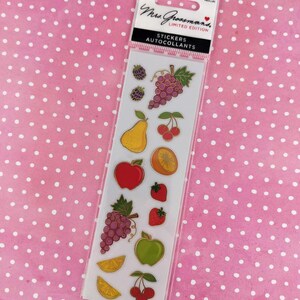 Puede incluir: Un paquete transparente de pegatinas de edición limitada de Mrs. Grossman con ilustraciones de frutas coloridas. Las pegatinas incluyen uvas, manzanas, peras, cerezas, fresas y rodajas de naranja. El paquete tiene el texto "Stickers Autocollants".