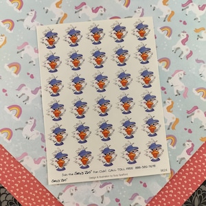 May include: A sheet of stickers featuring a cartoon duck wearing a blue baseball cap. The stickers are on a white background and are surrounded by a blue and white unicorn pattern. The text "Join the Suzy's Zoo Fan Club! CALL TOLL FREE 888-385-7678" and "Sey's Zoo" are printed at the bottom of the sheet.