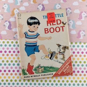May include: Vintage children's book titled "The Little Red Boot" featuring a boy in blue shorts and a striped shirt kicking a dog. The cover art includes the book title, a bird, and the Rand McNally Publisher logo.