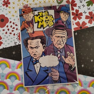 Peut inclure: Une couverture de bande dessinée représentant quatre hommes en costume et chapeau. Le titre de la bande dessinée est "The Knob Mob".