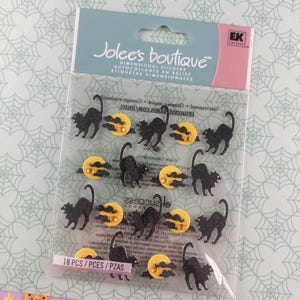 以下が含まれることがあります： Jolee's Boutiqueの立体ステッカーのパッケージ。黒猫と雲のある黄色い月が特徴で、ハロウィーンのクラフトに最適です。パッケージには18個入りです。