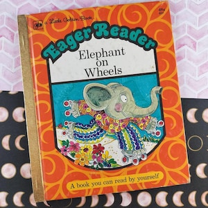 May include: A vintage Little Golden Book titled "Eager Reader Elephant on Wheels." The cover features a cartoon elephant on roller skates, set against an orange background with the book's title in a playful font. The book has a gold spine.
