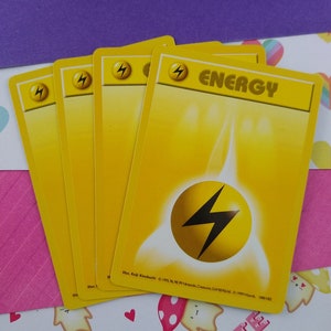 May include: Five yellow Pokemon trading cards with the word "ENERGY" printed on the top card. The cards feature a yellow lightning bolt symbol.