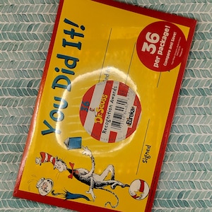 May include: A yellow and red card with the text "You Did It!" and a cartoon image of the Cat in the Hat. The card also features a sticker with the text "Dr. Seuss Recognition Awards" and a barcode. The back of the card has the text "Signed" and "36 per package! Compare and Save!"