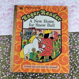 May include: Vintage children's book titled "Eager Reader: A New Home for Snow Ball." The cover is orange with a cartoon illustration of a horse, a king, and a castle. The book is a Little Golden Book.