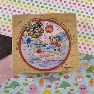 Puede incluir: Bloque de madera con una pintura de acuarela de globos aerostáticos sobre un paisaje. La obra de arte incluye el texto "No matter how impossible it all may seem... never underestimate the power of a dream."