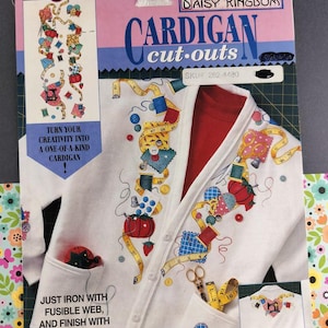 May include: A white cardigan cut-out kit with colorful sewing-themed designs. The kit includes a design for the front and back of the cardigan, with text that reads "Turn your creativity into a one-of-a-kind cardigan!" and "Just iron with fusible web, and finish with slick paint."