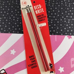 May include: A vintage package of Craftint Deco-Write iron-on transfer pencils. The red pencils are displayed on a red and white card with the text "DECO-WRITE" and "MAKE YOUR OWN STAMPED GOODS". The background is a black surface with white stars.