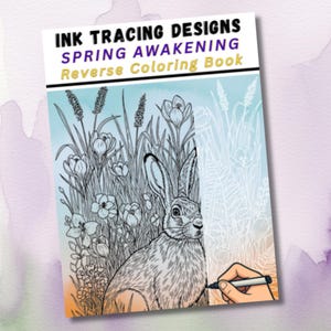 Pode incluir: Um livro de colorir inverso intitulado "INK TRACING DESIGNS SPRING AWAKENING". A capa apresenta uma ilustração detalhada de um coelho em meio a flores e capim alto. Uma mão é mostrada usando uma caneta preta para traçar o desenho.