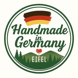 May include: A round, white sticker with a green border. The sticker features the text "Handmade in Germany" in a script font, along with a depiction of the German flag and a heart. Below the text is a green mountain range with the word "EIFEL".