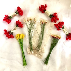 May include: Assortment of artificial flower stems, including red berry sprigs and yellow and white flower sprigs. The stems are packaged in clear plastic bags.