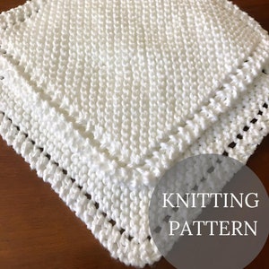 May include: White knitted blanket with a simple stitch pattern and a border. The blanket is folded in half and the text "Knitting Pattern" is visible in the lower right corner.