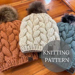 Könnte beinhalten: Drei gestrickte Mützen in Orange-, Creme- und Türkistönen, jede mit einem geflochtenen Zopfmuster und einem Kunstfell-Bommel. Der Text "KNITTING PATTERN" ist auf dem Bild überlagert.