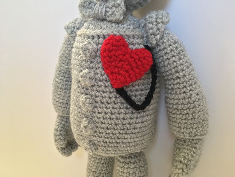 Op de afbeelding: Een grijs gehaakt knuffeldier van de Tin Man uit The Wizard of Oz. Het speelgoed heeft een rood hart op zijn borst genaaid.