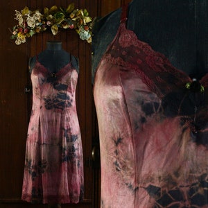 May include: A vintage pink and black tie-dye slip dress with lace trim. The dress has a fitted bodice and a flowing skirt.