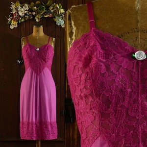 Könnte beinhalten: Ein vintage rosafarbener Spitzen-Slip mit einem Satin-Oberteil und einem Spitzenbesatz. Der Slip hat verstellbare Träger und einen Knopfverschluss oben.