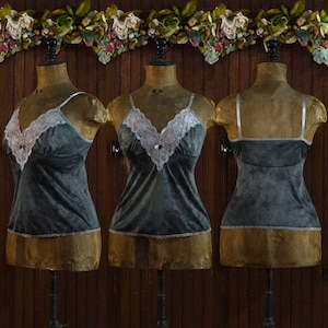 May include: Three mannequins wearing gray velvet camisoles with lace trim. The camisoles have adjustable straps and a V-neckline.