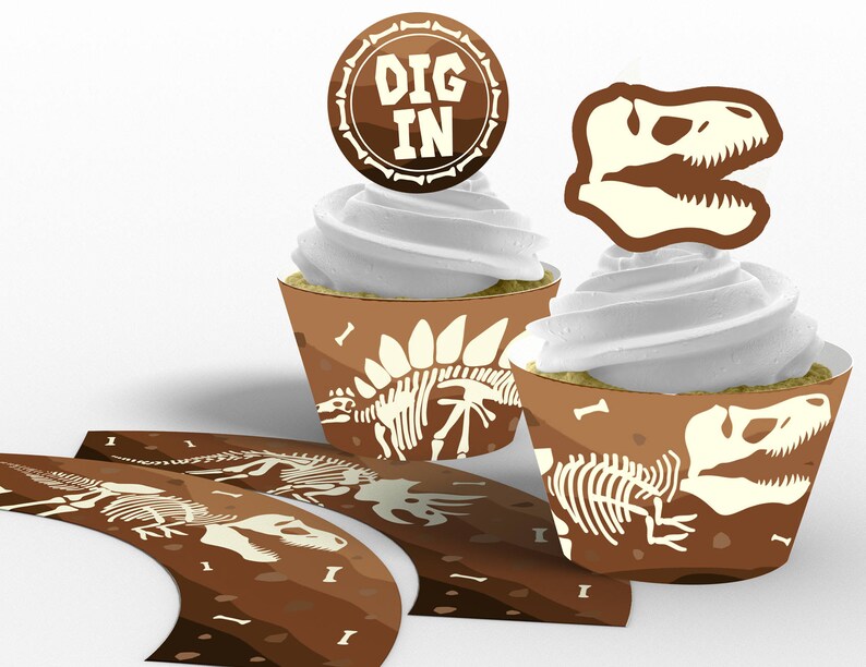 May include: Brown cupcake wrappers with a dinosaur skeleton design and the text "DIG IN". The wrappers are decorated with a brown and white dinosaur skeleton design.