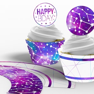 May include: Purple and blue galaxy themed cupcake wrappers with white stars and constellations. The wrappers have a white background with a purple and blue watercolor effect. The cupcake wrappers are topped with white frosting and a round purple and blue cupcake topper with the text "Happy Bday" in white.