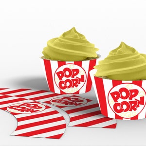 May include: Two yellow frosted cupcakes with red and white striped cupcake liners. The liners have a red circle with the text "POP CORN" in white letters.