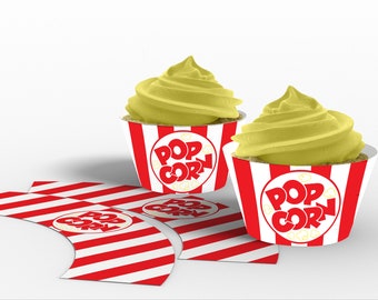 Può includere: Due cupcake con glassa gialla e pirottini a righe rosse e bianche. I pirottini hanno un cerchio rosso con il testo "POP CORN" in lettere bianche.