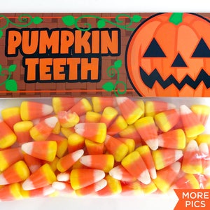 Könnte beinhalten: Eine durchsichtige Plastiktüte gefüllt mit orangefarbenem und weißem Candy Corn. Die Tüte hat ein Etikett mit einem braunen Ziegelmuster und grünen Ranken. Das Etikett lautet "Pumpkin Teeth" und zeigt einen orangefarbenen Cartoon-Kürbis mit einem schwarzen Gesicht.
