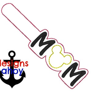 May include: A pink and yellow embroidered iron-on patch with the word "MOM" and a Mickey Mouse head in the center.