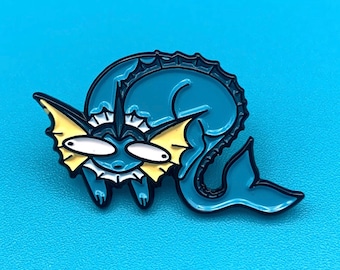 May include: A teal enamel pin depicting a cartoon creature with large eyes and a tail. The pin has yellow accents on the fins and a white mouth. The pin is set against a solid blue background.