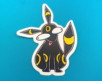 May include: Black and yellow cartoon sticker of a Pokemon character with large eyes and a tongue sticking out.