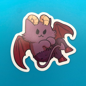 May include: A purple and red cartoon devil cat with horns and a tail. The cat has a mischievous expression and is wearing a red cape.