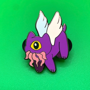 May include: Purple winged creature with a single yellow eye and pink tentacles coming out of its mouth. The creature has white wings and is in a flying pose.