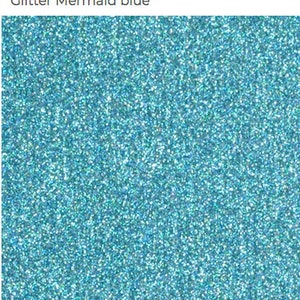 May include: A close-up of blue glitter with a fine texture. The glitter is a light blue color with a slight iridescent sheen.