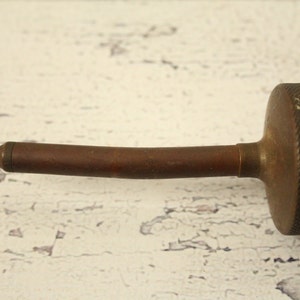 May include: A vintage oil can with a long, curved spout. The can is made of metal and has a worn, brown finish.