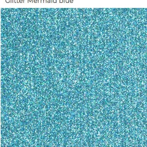 May include: A close-up of blue glitter with a fine texture. The glitter is a light blue color with a slight iridescent sheen.