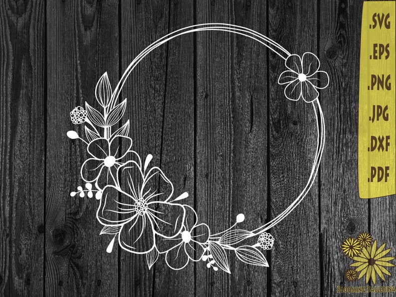 May include: A white floral wreath with a circular frame. The wreath is made of stylized flowers and leaves. The wreath is on a dark wood background.