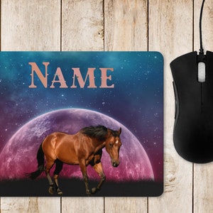 May include: A personalised mouse mat featuring a brown horse running in front of a pink and purple moon with a starry night sky background. The text "NAME" is at the top of the mouse mat.