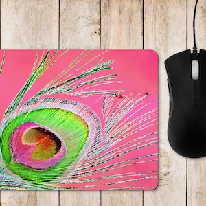May include: A pink mouse mat with a close-up of a green, pink and white peacock feather.