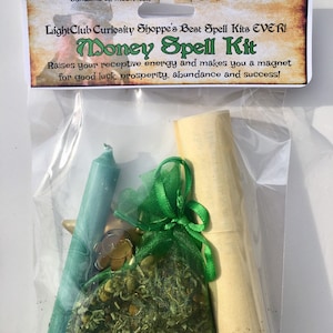 May include: A clear plastic bag containing a money spell kit. The kit includes a green candle, a small green pouch with a gold charm, a rolled up piece of parchment paper, and a bag of dried herbs. The bag has a label that reads "Light Club Curiosity Shoppe's Best Spell Kits EVER! Money Spell Kit Raises your receptive energy and makes you a magnet for good luck, prosperity, abundance and success!"