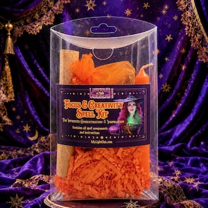 May include: A clear plastic box containing a Focus & Creativity Spell Kit with orange shredded paper, an orange organza bag, a tan scroll, and an orange candle. The label features a person with pink hair and the text MyLightClub.com.