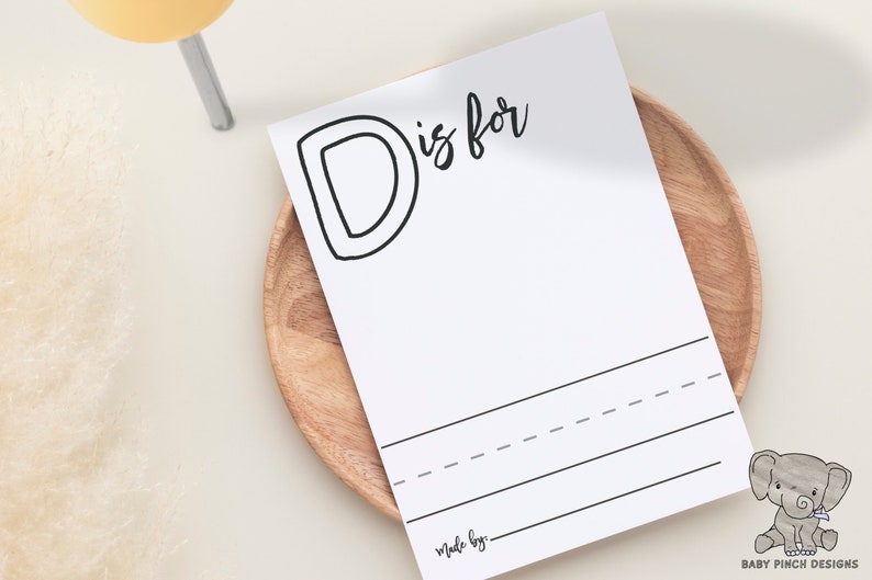 blank coloring page letter D sitting on top of a bamboo plate with shadows and dried flowers