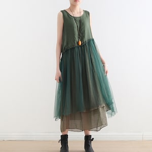 May include: A green sleeveless dress with a tulle overlay. The dress has a ruffled hem and a brown underskirt.