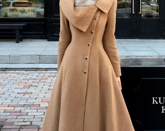May include: A long, tan coat with a wide collar and fur trim. The coat features gold buttons and a flared skirt. A brown hat completes the look. The coat is a classic style, suitable for cold weather.