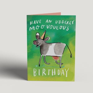 Op de afbeelding: Een groene verjaardagskaart met een cartoonkoe die een feestmuts draagt. De kaart zegt "Have an udderly moo-vellous birthday".