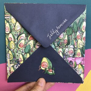May include: A blue envelope with a pattern of cartoon avocados on the front. The envelope has the text "Jelly Armchair" written on the front in white.