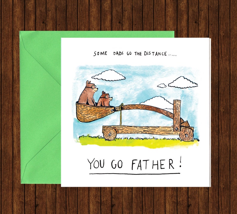 Pu&ograve; includere: Un biglietto d'auguri umoristico per la Festa del Pap&agrave; con un'illustrazione di due orsi in stile cartone animato che cavalcano una catapulta. Il testo recita "Alcuni pap&agrave; fanno la distanza... Tu vai pi&ugrave; lontano!"